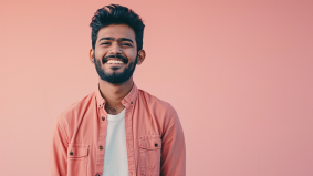 Smiling in Pink: Bikash Bhattacharjee Poses with Confidence Against Vibrant Background